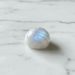 Natural Rainbow Moonstone crystal with blue sheen on white marble – Horocosmo