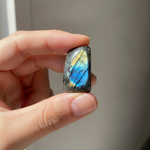 Natural Labradorite crystal held in hand for scale – Horocosmo