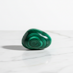 Natural Malachite crystal with green banding on white marble – Horocosmo