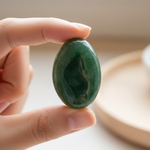 Natural Green Jade stone held in hand for scale – Horocosmo