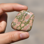 Natural Unakite stone held in hand for scale – Horocosmo