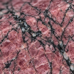 Macro texture of natural Rhodonite showing pink and black manganese veins – Horocosmo