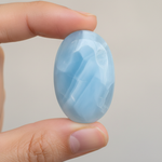 Natural Blue Chalcedony stone held in hand for scale – Horocosmo