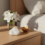 Howlite stone on a calm bedside table with brass diya and white flowers – Horocosmo