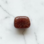 Man-made Goldstone with sparkling copper on white marble – Horocosmo