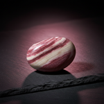 Natural Rhodochrosite rose-pink stone with glow on dark background – Horocosmo
