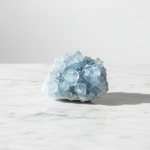 Natural Celestite sky-blue cluster on white marble – Horocosmo