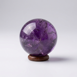 Natural Amethyst crystal sphere on wooden stand – representative image; each natural stone varies slightly in pattern and shade